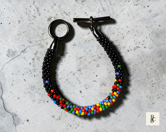 Confetti Explosion Pride Kumihimo bracelet with multicolor glass seed beads, detailed angled view