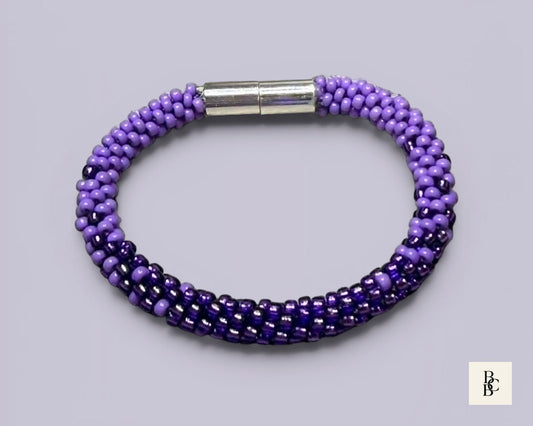 Shades of Violet handmade Alzheimer’s Awareness Kumihimo bracelet with purple glass seed beads and a silver-tone magnetic clasp.