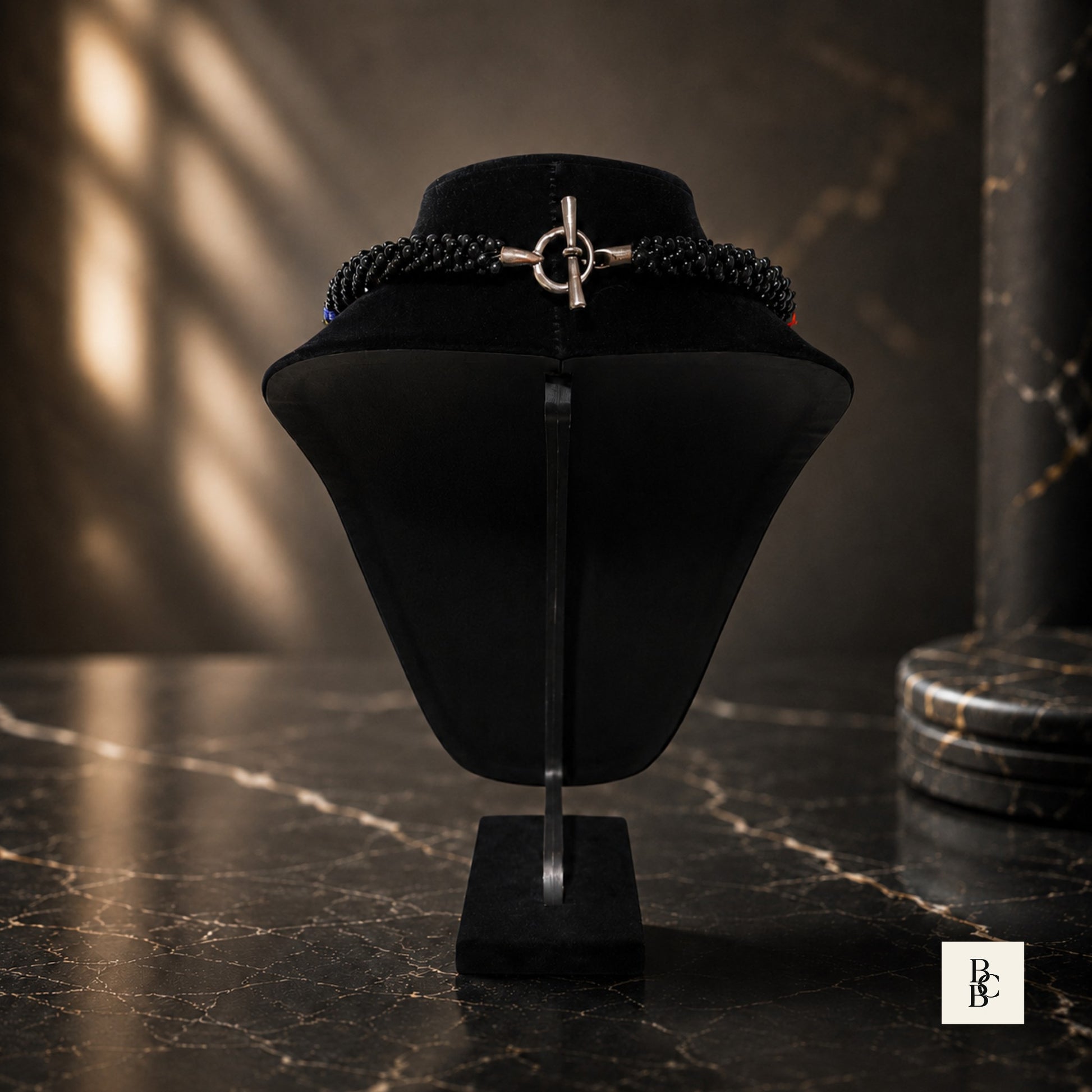 Back view of Rainbow Illusion Kumihimo necklace on black display, showing silver-tone toggle clasp and black beaded ends