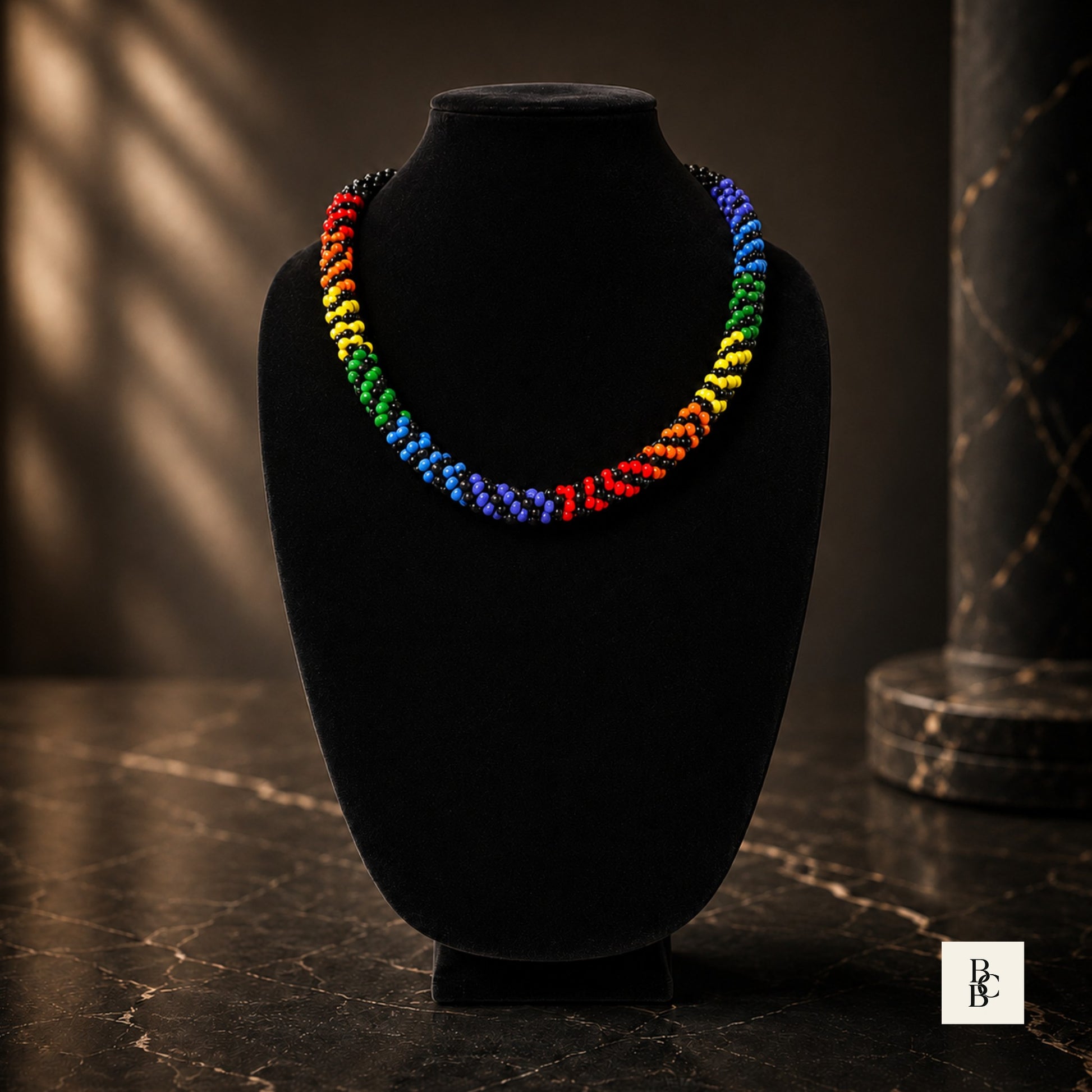 Rainbow Illusion Pride Kumihimo necklace angled product view on black velvet bust with bold rainbow glass bead accents